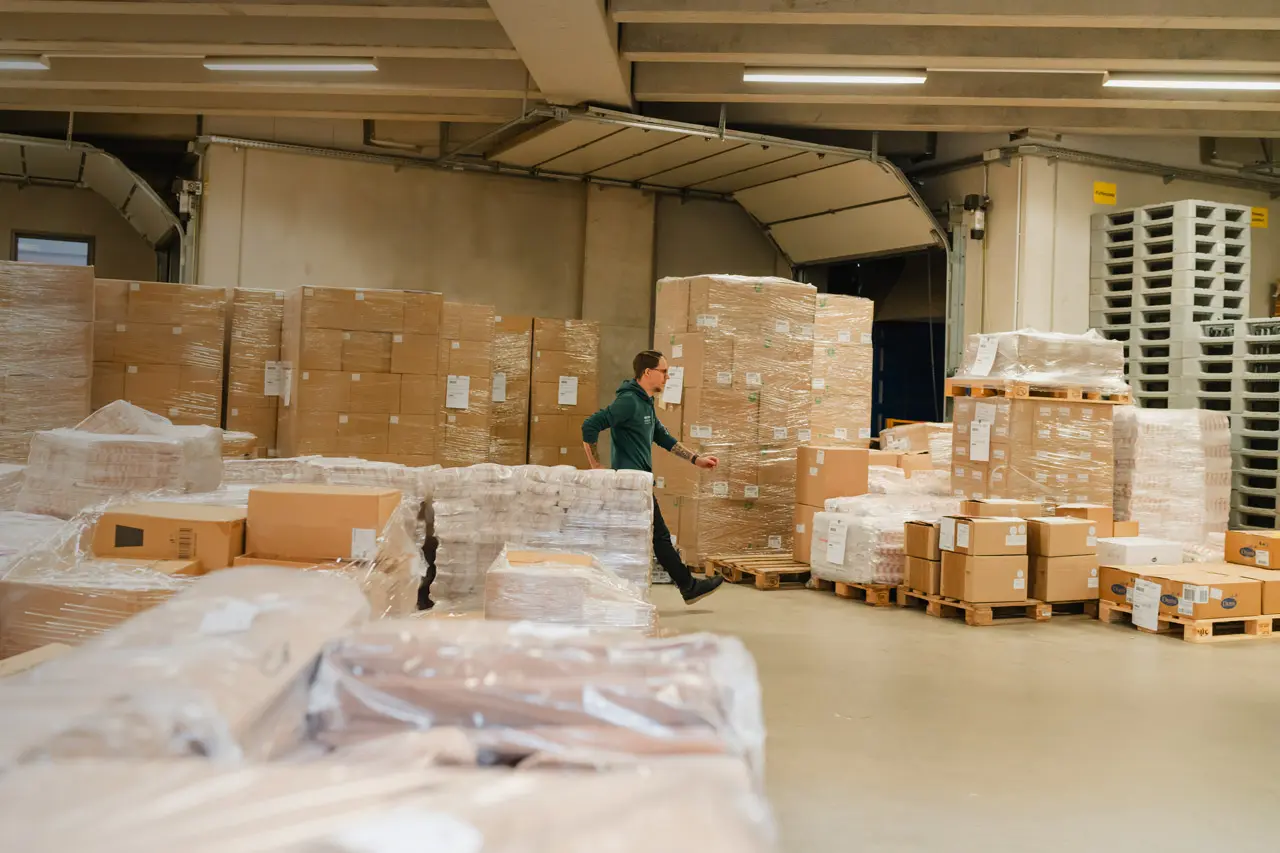 MEDEWO GRUPPEN Mitarbeiter läuft durch das Verpackungslager